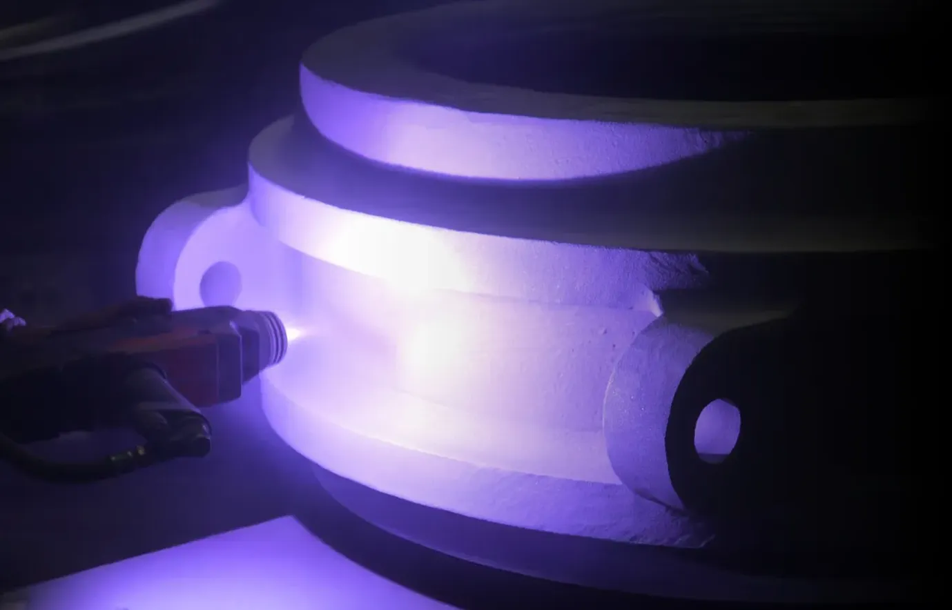 Bright flash during metal coating. The machine applies the coating to an component. Deutsch: Helles Licht während der Beschichtung mit Metall. Die Maschine verzinkt ein Gehäuse.
